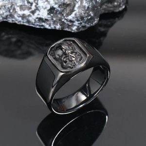 Macro shot of a black punk skull ring reflected on a dark mirrored surface with rocks