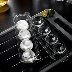 Transparent round ice ball mold for 4 large ice spheres on a black kitchen tray