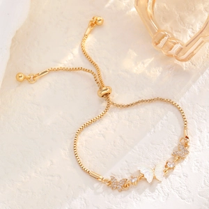 Detail of adjustable gold butterfly bracelet with mother of pearl and zircon stones
