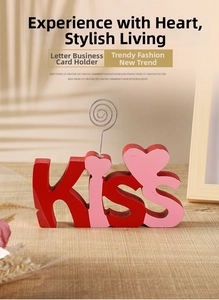 Close-up of wooden KISS letter card holder with heart details and metal photo clip