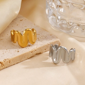 Minimalist 18K gold and silver plated wavy open rings on a textured stone tray