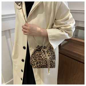 Detail of leopard print bucket bag with gold chain strap and elegant pearl accents