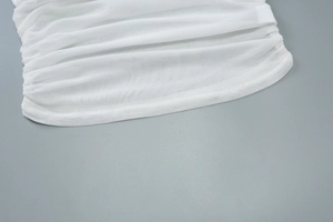 Détail de tissu en résille blanche avec design plissé et coutures de qualité sur un caraco