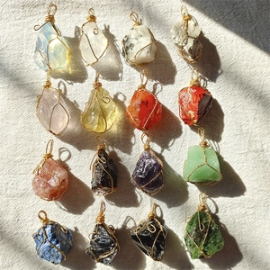 Detailed grid of 16 handcrafted natural crystal pendants wrapped in gold wire