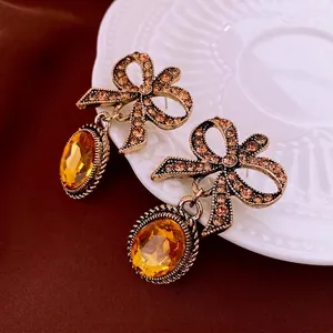 Vintage gold bow earrings with champagne crystals and amber gems in a luxury style