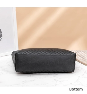 Detail view of the rectangular black leather tote bag bottom with V-shaped quilting
