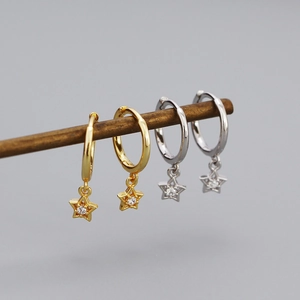 Macro detail of gold and silver star earrings with sparkling cubic zirconia stones