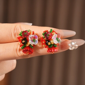 Close-up of handmade vintage floral earrings with colorful glass beads and resin clusters