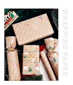 Close-up of brown kraft Christmas wrapping paper with festive patterns on green velvet