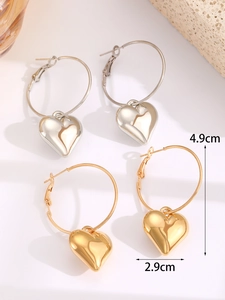 Detail view of large hoop earrings with heart charms showing 4.9cm height and 2.9cm width