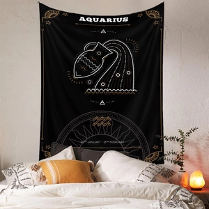 Close-up of black and gold Aquarius zodiac tapestry hanging in a cozy bedroom setting