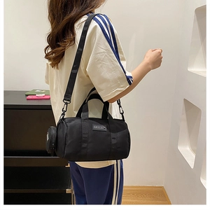 Detail of black nylon Boston bag with adjustable wide strap and mini coin purse hanging