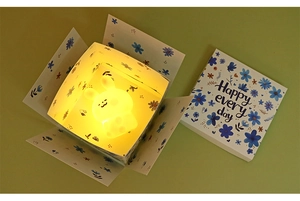 Gros plan d'une veilleuse lapin jaune chaud brillant dans une boîte cadeau à fleurs