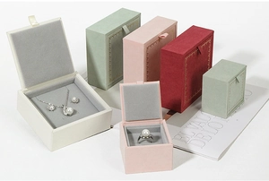 Detailed view of jewelry gift boxes in beige, green and pink with plush velvet lining