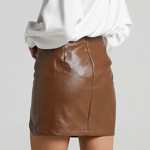 Detail of high-waist brown PU leather mini skirt featuring back zipper closure