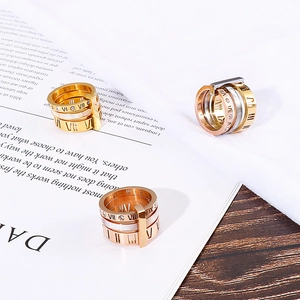 Close-up of stacked Roman numeral cut-out rings in gold and rose gold with zircon inlay