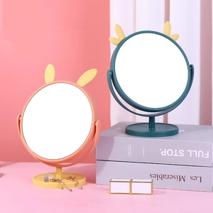 Rotating desktop makeup mirror with cute cat ears and jewelry storage base in soft lighting