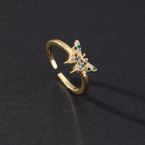 Detail of a golden open ring featuring a colorful butterfly set with vibrant zircons