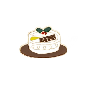 Retro Christmas cake enamel brooch with festive Xmos lettering in white and green