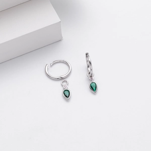 Detailed macro of S925 silver hoop earrings with a drop-shaped green zircon stone