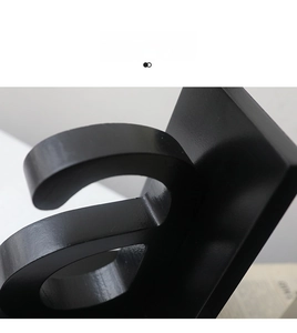 Macro shot of matte black metal letter bookend showing round corners and smooth texture