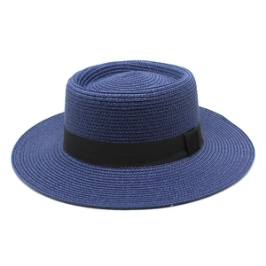 Detailed view of the navy blue straw boater hat featuring a black grosgrain ribbon band