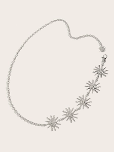 Détail de la chaîne de taille en métal argenté avec pendentifs soleil en relief sur ceinture