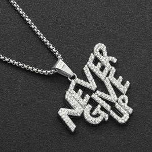 Macro shot of silver iced out Never Give Up letter pendant with shiny box chain