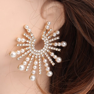 Macro view of sunflower stud earrings with pearls and rhinestones on gold alloy base