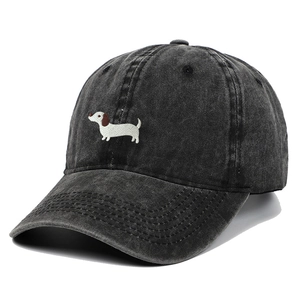 Macro detail of dachshund embroidery on washed black cotton baseball cap fabric