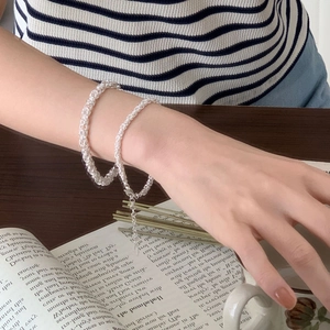 Minimalist 925 sterling silver braided bracelet worn on wrist near vintage props