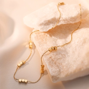Minimalist 18K gold plated titanium steel necklace with cubic beads on white stone decor