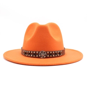 Close-up of bright orange wool fedora hat featuring a leather band with vintage metal rivets
