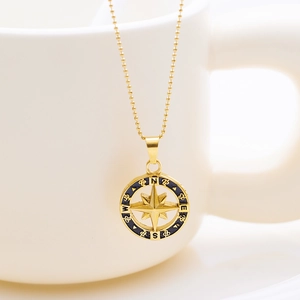 Collar vintage de oro con colgante de brújula de estrella y detalle de esmalte negro