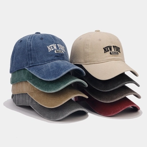 Detail of vintage washed cotton baseball caps with New York 1625 embroidery in multiple colors