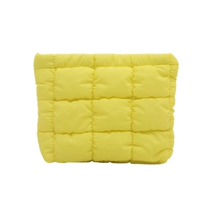 Bright yellow quilted makeup bag with soft padded texture and square puffer stitching