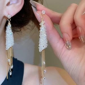 Detailed view of elegant gold tassel earrings with square zircon and crystal fringe