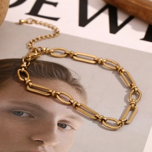 Detail of 14K gold-plated stainless steel paperclip and O-link chain with cross buckle clasp