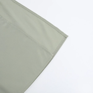 Gros plan détaillé montrant les coutures professionnelles et la texture du satin vert sauge