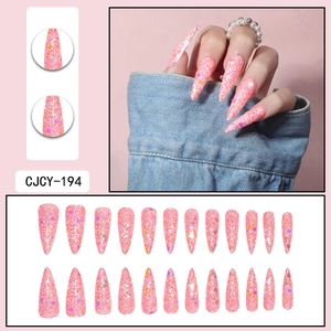 Detailed macro view of long stiletto press-on nails with pink glitter and sequins