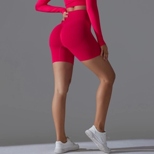 Detail of high-waist peach lift yoga shorts and long sleeve crop top in rose red seamless knit