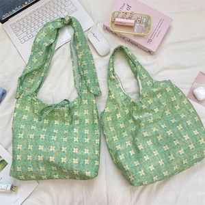 Detailed comparison of green floral canvas tote bags with tie-strap and handle designs