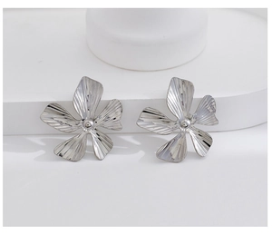 Detail of silver five-petal flower earring with brushed metal finish and center bead
