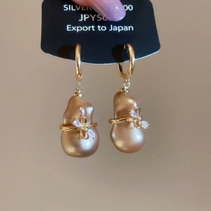 Gros plan sur les boucles d'oreilles en perles baroques plaquées or 18 carats avec zircons