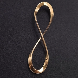 Macro shot of gold stainless steel infinity pendant on a dark textured background