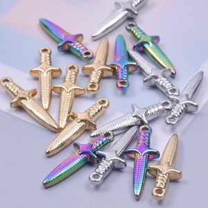 Dettaglio di ciondoli a forma di pugnale in acciaio inossidabile oro 18k e arcobaleno