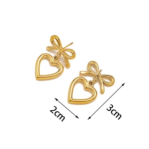 Dettaglio orecchini a fiocco e cuore dorati con dimensioni 2 cm di larghezza e 3 cm