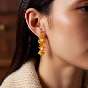 Gros plan de boucles d'oreilles pendantes plaquées or 18 carats avec perles sur un mannequin