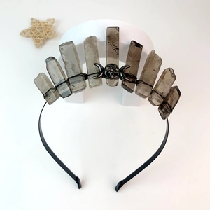 Macro detail of handmade smoky quartz crystal crown with pentagram and moon charms