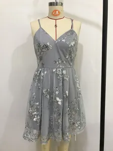 Dettaglio di ricami floreali in paillettes d'argento su abito da festa in rete
